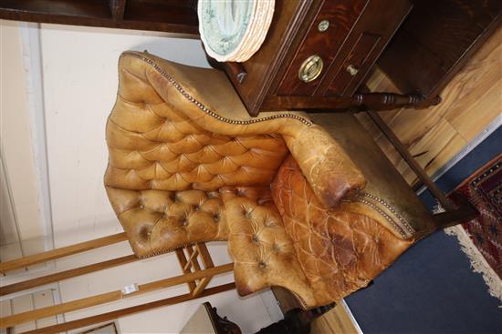 A pair of leather tan wing armchairs